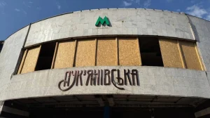 Фасад станції метро Лукянівська із забитими фанерою вікнами та зеленим логотипом М