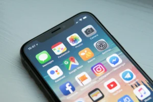 Чорний смартфон з екраном, повним іконок додатків і соцмереж