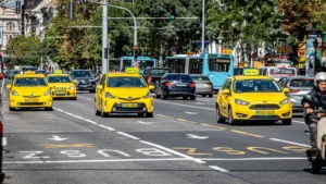 Жовті таксі Bolt серед міського трафіку з автобусами та скутером